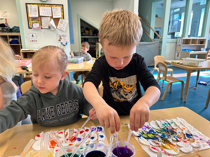 A preschool age boy and girl painting