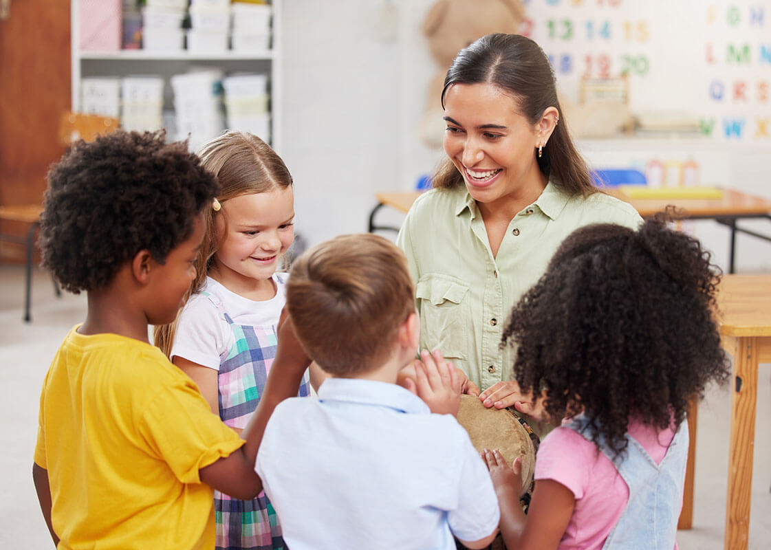 Three preschool age children engaging with their classroom teacher