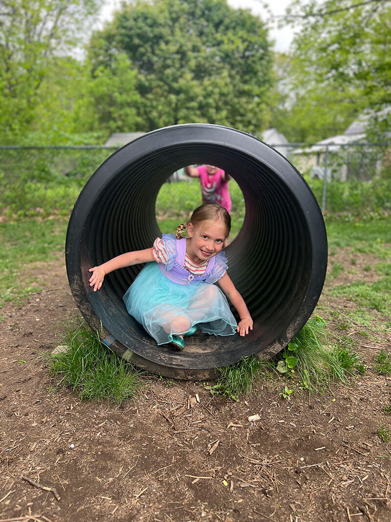 Young girl on the playground in a tunnel