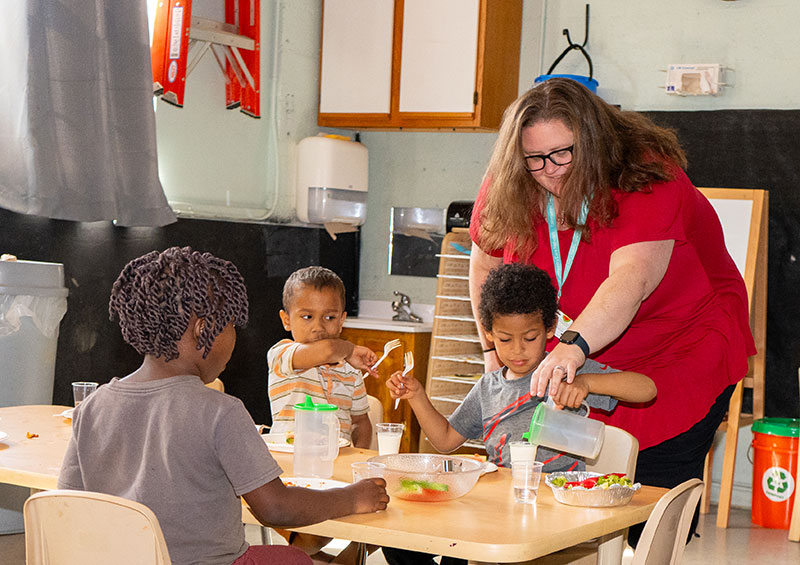 Head Start teacher working with three children