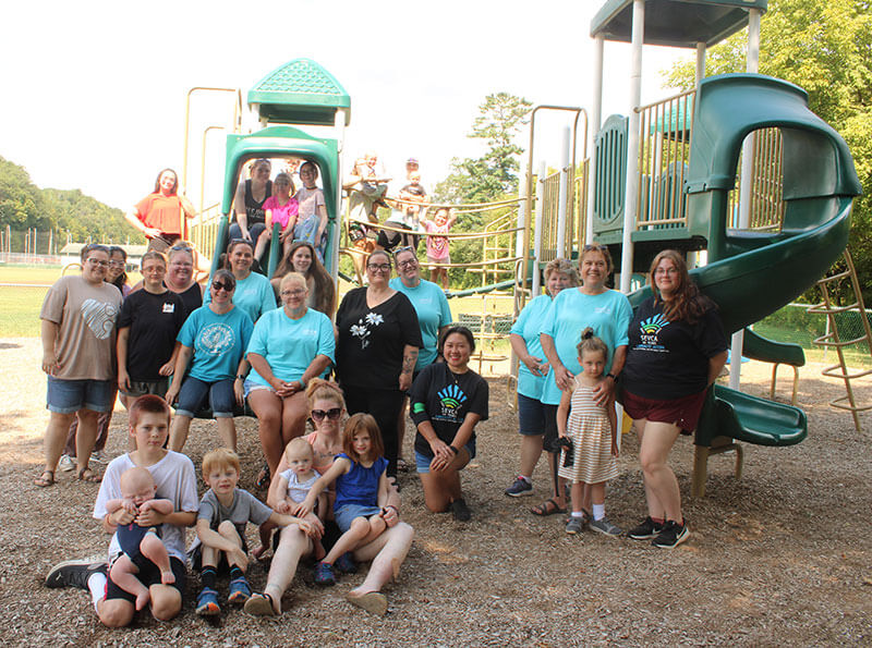 Staff and kids in a group photo on the playground