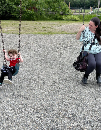 Mother with you young daughter each on their own swing